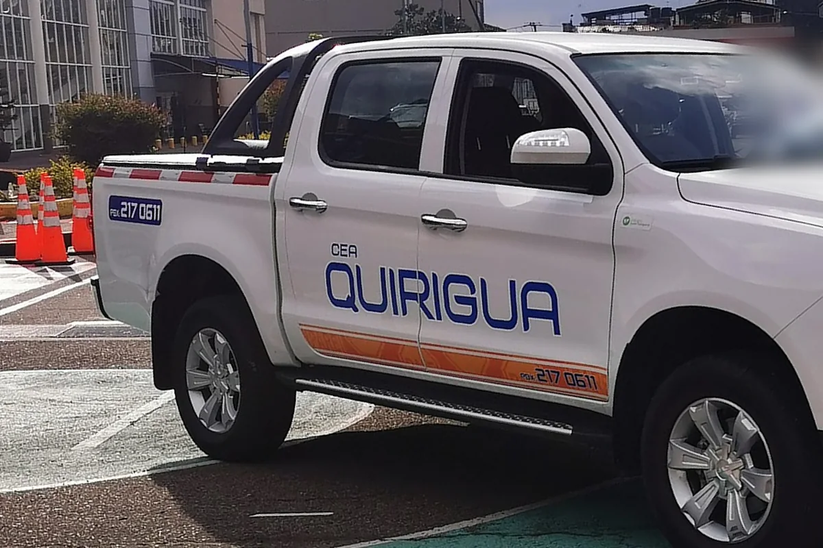 La camioneta de la escuela junto a la fila de conos del circuito de práctica.